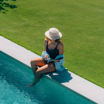 Gazon synthétique Excellence 62 - 62 mm au bord d'une piscine avec fibres hautes offrant un confort exceptionnel